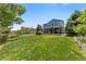 Inviting backyard with a lush lawn, charming blue house, mature trees, and a white picket fence at 21885 Whirlaway Ave, Parker, CO 80138