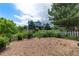 Landscaped backyard featuring a gravel area, lush lawn, a white picket fence, and trees at 21885 Whirlaway Ave, Parker, CO 80138