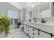 Modern bathroom features dual vanities, marble floors, and stylish fixtures at 21885 Whirlaway Ave, Parker, CO 80138