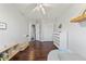 Neutral toned bedroom with ceiling fan, dresser, dark wood floors and natural light at 21885 Whirlaway Ave, Parker, CO 80138