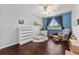 Cozy bedroom featuring a rocking chair, dark wood floors and a window at 21885 Whirlaway Ave, Parker, CO 80138
