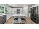 Modern kitchen with white cabinets, stainless steel appliances, large island with seating, and stylish backsplash at 21885 Whirlaway Ave, Parker, CO 80138