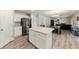 Open-concept kitchen with white cabinets, stainless steel fridge, center island, and adjacent dining area at 21885 Whirlaway Ave, Parker, CO 80138