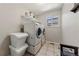 Practical laundry room with stacked washer and dryer and tile floor at 21885 Whirlaway Ave, Parker, CO 80138