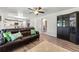 Cozy living room featuring a leather sofa, hardwood floors, and open view into the updated kitchen at 21885 Whirlaway Ave, Parker, CO 80138