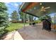 Enjoyable outdoor patio with stone flooring, ceiling fans, grill, and view of the landscaped yard at 21885 Whirlaway Ave, Parker, CO 80138