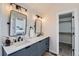 Elegant bathroom featuring double vanity, modern fixtures, and a doorway to the walk-in closet at 13547 Quivas St, Denver, CO 80234