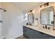 Modern bathroom featuring double sinks, elegant lighting, and a walk-in shower with white tile at 13547 Quivas St, Denver, CO 80234