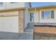 View of the property's front door, with an attached two-car garage and brick accents at 13547 Quivas St, Denver, CO 80234