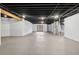Spacious unfinished basement with a painted floor, exposed ceiling, and walkout access at 9303 Dauntless Way, Conifer, CO 80433