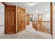 Second floor hallway with carpet and wood railing leading to bedrooms and other rooms at 9303 Dauntless Way, Conifer, CO 80433