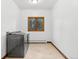 Bright laundry room featuring a large window and modern gray washer and dryer at 9303 Dauntless Way, Conifer, CO 80433