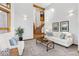 Stylish living room with white furniture, large windows, and a view of the staircase at 9303 Dauntless Way, Conifer, CO 80433
