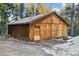 Exterior shot of a weathered wooden shed with a simple door and a surrounding natural landscape at 9303 Dauntless Way, Conifer, CO 80433