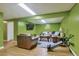 Cozy basement with green walls, wood floors, plush seating, and exercise equipment at 983 S Ouray St, Aurora, CO 80017