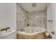 Contemporary bathroom features a soaking tub with marble-patterned tile surround and travertine tile base at 983 S Ouray St, Aurora, CO 80017