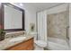 Bathroom featuring vanity with granite countertop and tub/shower combo with marble tile surround at 983 S Ouray St, Aurora, CO 80017