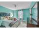 Cozy bedroom with teal walls, wood floor, a large bed, and dresser under a mirror with natural light at 983 S Ouray St, Aurora, CO 80017