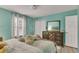 Bedroom featuring teal walls, light wood floor, bed, and dresser near a window for natural light at 983 S Ouray St, Aurora, CO 80017