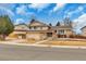 Charming two-story home featuring a brick facade, attached garage, and a well-maintained front yard with mature trees at 983 S Ouray St, Aurora, CO 80017