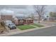 Charming brick home featuring a cozy front porch and manicured lawn at 10948 Murray Dr, Northglenn, CO 80233