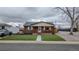 Charming brick home featuring a cozy front porch and manicured lawn at 10948 Murray Dr, Northglenn, CO 80233