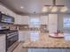 Bright kitchen with white cabinets, granite countertops, stainless steel appliances, and a stylish tile backsplash at 10948 Murray Dr, Northglenn, CO 80233