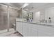 Well-lit bathroom featuring double sinks with granite countertops, a glass shower, and white cabinetry at 723 176Th Ave, Broomfield, CO 80023