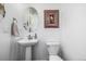 Charming powder room features pedestal sink, decorative mirror, and framed artwork at 723 176Th Ave, Broomfield, CO 80023