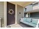 Inviting front porch with a colorful floral wreath, a cozy bench and decorative pillows at 723 176Th Ave, Broomfield, CO 80023