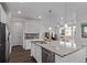 Open kitchen area with a granite island and stainless appliances leads into the living room with dark hardwood floors at 723 176Th Ave, Broomfield, CO 80023