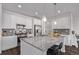 Bright kitchen features white cabinets, stainless steel appliances, a large island with a stone countertop, and modern pendant lighting at 723 176Th Ave, Broomfield, CO 80023