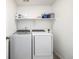 Modern laundry room with side by side washer and dryer and a shelf with laundry detergent at 723 176Th Ave, Broomfield, CO 80023