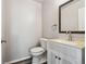 Powder bathroom featuring modern sink with vanity, mirror, and hardwood floors at 8588 Sweet Clover Way, Parker, CO 80134