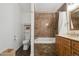 Bathroom featuring a shower-tub combo, toilet, and vanity with marble backsplash at 8588 Sweet Clover Way, Parker, CO 80134