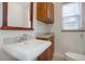 Small bathroom with pedestal sink, toilet, and wood cabinets at 35 S Washington St # 1-2, Denver, CO 80209