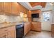 Modern kitchen with wood cabinets, granite counters, and a door to outside at 35 S Washington St # 1-2, Denver, CO 80209