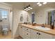 Bathroom featuring dual sinks, white cabinetry, and a separate toilet area at 10828 Valleybrook Cir, Highlands Ranch, CO 80130