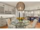 A dining area with a view of the kitchen, featuring a wine cooler, cabinets, and a stylish light fixture at 10828 Valleybrook Cir, Highlands Ranch, CO 80130