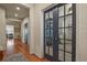 Elegant hallway with hardwood floors, featuring stylish glass paneled French doors and views into the open concept living spaces at 10828 Valleybrook Cir, Highlands Ranch, CO 80130