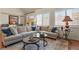Comfortable living room featuring a large sectional sofa, hardwood floors, and large windows to enjoy the outdoor views at 10828 Valleybrook Cir, Highlands Ranch, CO 80130