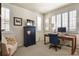 Cozy office nook featuring plantation shutters, a dark wooden desk and soft chair with blanket creating a productive workspace at 10828 Valleybrook Cir, Highlands Ranch, CO 80130