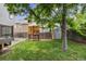 Beautiful backyard features a treehouse, swing set, storage shed and lush lawn at 12193 Deerfield Way, Broomfield, CO 80020
