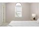 Comfortable bedroom featuring a neutral color scheme, arched window, and a comfortable queen bed at 12193 Deerfield Way, Broomfield, CO 80020
