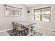 Dining area featuring wood-look flooring, large windows, and a stylish gray table with bench at 12193 Deerfield Way, Broomfield, CO 80020