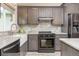Stylish kitchen features gray cabinets, subway tile backsplash, stainless steel appliances, and farm sink at 12193 Deerfield Way, Broomfield, CO 80020