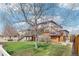 Picturesque backyard showcasing a multi-level deck, lush lawn, and mature trees at 20087 E Dartmouth Dr, Aurora, CO 80013
