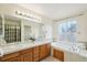 Well-lit bathroom featuring double sinks, a soaking tub, and a separate shower, perfect for relaxation at 20087 E Dartmouth Dr, Aurora, CO 80013