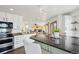 Open kitchen with white cabinets, a breakfast bar, and stainless steel appliances at 20087 E Dartmouth Dr, Aurora, CO 80013