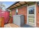 Back porch featuring a storage cabinet, storm door, and brick exterior walls at 2614 E 13Th Ave, Denver, CO 80206